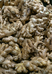 Fresh organic ginger roots on the market in a crate.