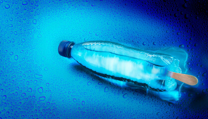 Water bottle with ice cream stick against blue background with water drops