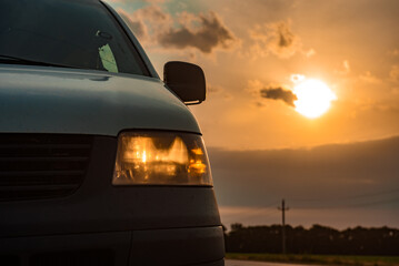 Modern automotive optics against the backdrop of a warm summer sunset. copy space for text. The concept of polishing, repairing or replacing a car headlight 
