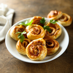 Obraz na płótnie Canvas Homemade puff pastry swirls with bacon and tomato