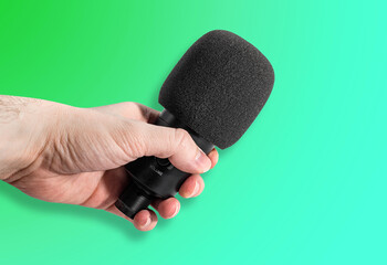 Hand with a microphone on the background. Concept for voice recording, interviewing, music making. Editing and improving music.