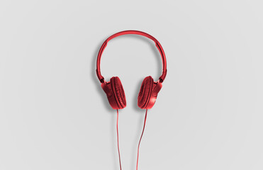 Computer headphones. Red headphones on a white background. The concept of listening to music, creating audio, music. Computer work, abstraction and minimalist style.