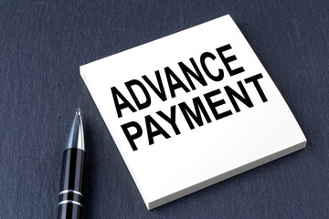 ADVANCE PAYMENT text on the sticker with pen on the black background