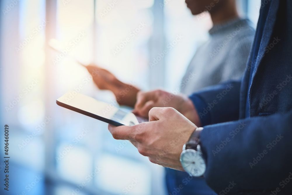 Poster connecting to the business world. closeup shot of two unrecognizable businesspeople using their digi