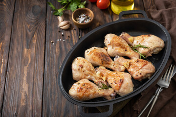 Baked grilled chicken legs  with rosemary on a wooden table. Copy space.