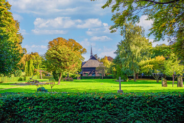 Lots of green trees, bushes, flowers and old chapel at Holmen Cemetery. Copenhagen, Denmark