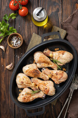 Baked grilled chicken legs  with rosemary on a wooden table. Top view flat lay.