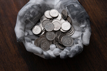 ruble coins in stone hands on a dark wooden background