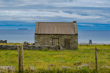 Irish old cottage standing on the cliffs