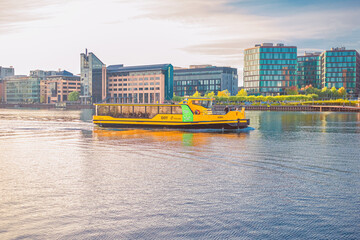 Yellow Copenhagen Harbour water Busesthe sails along the city canal  harbourfront near residential buildings of Copenhagen, Denmark - obrazy, fototapety, plakaty
