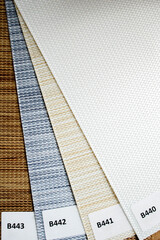 Samples of interior roller blinds of different textures and colors. use of roller blinds for sun...