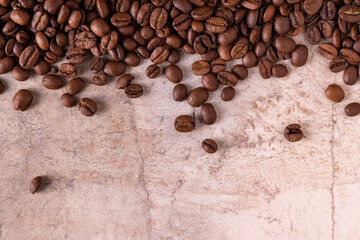 coffee beans are scattered over a beige background, close-up