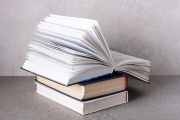 an open book lies on a stack of textbooks, copy space