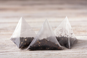 pyramids with tea leaves lies on a white wooden table