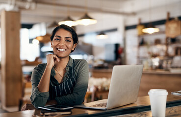 Nothing empowers you more than owning your own small business. Shot of a young woman using a laptop while working in a cafe.