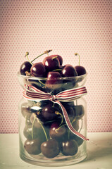 cherry fruit - cherries in a glass bowl with red ribbon and copy space in retro vintage style 