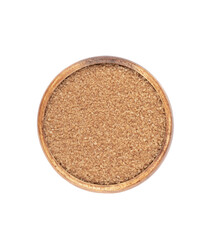 Top view of a wooden bowl with cane sugar on a white background.