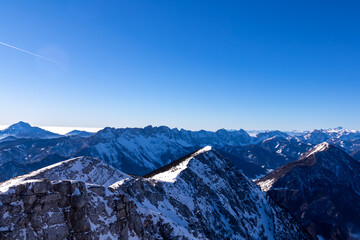 Scenic view from the summit of mount Hochobir on snow capped mountain peaks in the Karawanks in Carinthia, Austria. Winter wonderland on sunny day in Austrian Alps, Europe. Ski tour, snow shoe hiking.