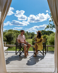 couple men and woman in front of an safari tent on luxury safari, South Africa, a luxury safari lodge in the bush of a Game reserve © Fokke Baarssen