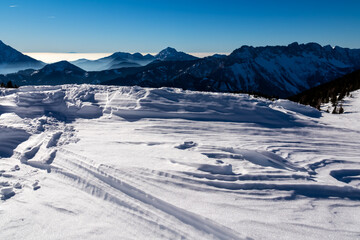 Panoramic view on snow capped mountain peaks of Karawanks in Carinthia, Austria. Julian Alps. Winter wonderland in the Austrian Alps, Europe. Ski tour, snow shoe hiking. Hochobir. Blue misty hills.