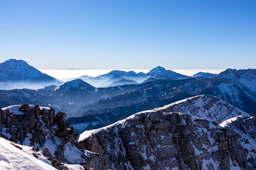 Scenic view from the summit of mount Hochobir on snow capped mountain peaks in the Karawanks in...