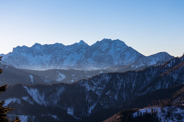 Early morning view on snow capped mountain peaks of Karawanks in Carinthia, Austria. Julian Alps. Scenic view on winter wonderland in the Austrian Alps, Europe. Ski tour, snow shoe hiking. Grintovec