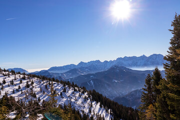 Panoramic view on snow capped mountain peaks of Karawanks in Carinthia, Austria. Julian Alps. Winter wonderland in the Austrian Alps, Europe. Ski tour, snow shoe hiking. Hochobir. Blue misty hills.