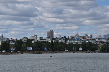 Naklejka premium Panoramic view of residential buildings in Voronezh and the reservoir. Cloudy day with clouds.
