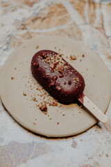Flat-lay of chocolate glazed ice cream pops with pistachio icing vegan healthy sugarfree