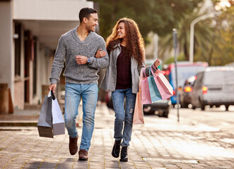 Theres always time for shopping. Full length shot of an affectionate young couple enjoying a shopping spree in the city.