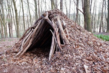 Bushcraft leaf hut shelter in woodland