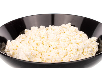 Fragrant tasty cottage cheese in a black ceramic plate, macro, isolated on a white background.