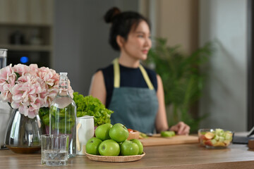 A portrait of a young pretty Asian woman eating an apple or trying a food, for food, health and cooking concept.