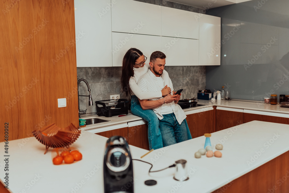 Wall mural young happy couple using two phones share social media news at home, smiling husband and wife millen