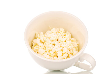 Fragrant tasty cottage cheese in a white ceramic cup, macro, isolated on a white background.