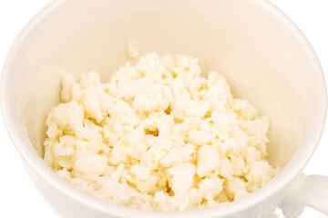 Fragrant tasty cottage cheese in a white ceramic cup, macro, isolated on a white background.
