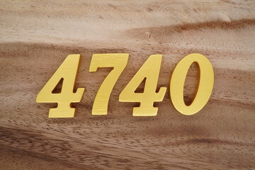 Golden Arabic numerals on a real brown and white wooden floor number 4740
