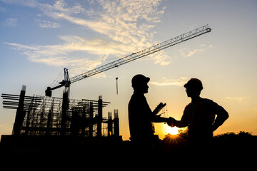 silhouettes of construction engineers or managers and construction workers on a construction site...