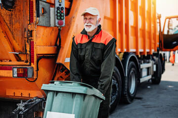 Mature worker of the city utility company on his job. Garbage collector. - obrazy, fototapety, plakaty