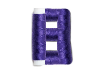 Letter of B from thread spools, isolated on white background. Alphabet concept.