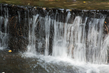 Fototapeta na wymiar Waterfall over rocks outdoors