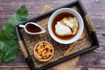 Douhua - soft tofu pudding (soy bean curd), Asian famous healthy dessert served in bamboo tray of wood table at top view