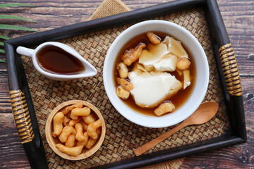 Douhua - soft tofu pudding (soy bean curd), Asian famous healthy dessert served in bamboo tray of wood table at top view