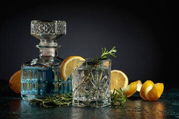 Gin tonic cocktail with lemon and rosemary.