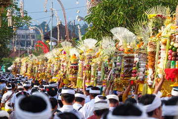Hindus are walking to the temple and holding a gebogan which contains various kinds of fruits,...