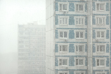 High-rise apartment blocks in a residential area of the city on a cloudy day in a snowfall