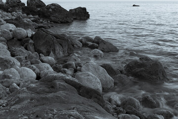 Background of stone beach with rocks, close-up. Grey stone beach for poster, calendar, post, screensaver, wallpaper, postcard, card, banner, cover, website. Black and white high quality photo