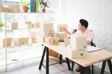 Southeast Asian man checking parcels before shipping