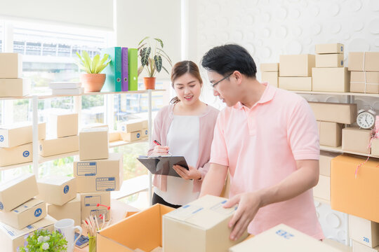 Male and female employees counting parcels to be delivered.