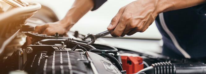Fototapeta Automobile mechanic repairman hands repairing a car engine automotive workshop with a wrench, car service and maintenance,Repair service. obraz